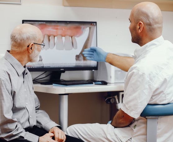 Dentiste expliquant un examen dentaire à l'écran à un patient