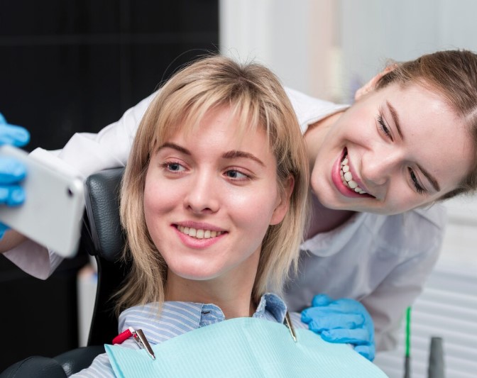 Patiente souriante et dentiste au cabinet dentaire