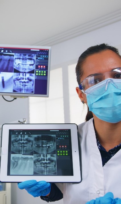 Dentiste présentant une radiographie panoramique sur tablette