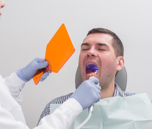 Soin dentaire avec lampe à polymériser sur un patient