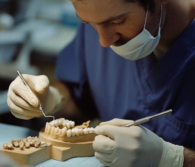 Prothésiste dentaire travaillant sur un modèle en laboratoire